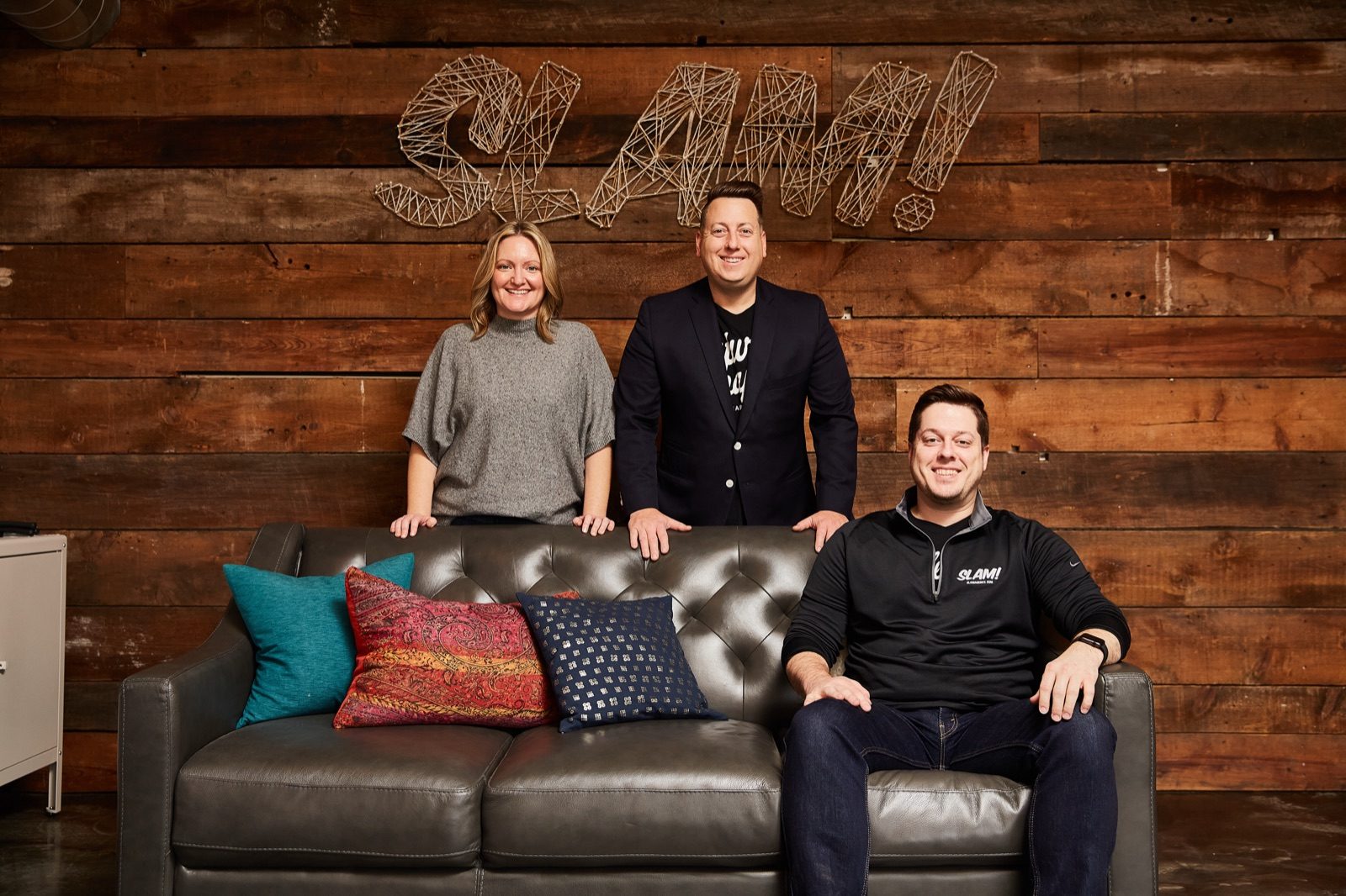 SLAM's three founding partners in the SLAM studio, beneath the string-art SLAM sign