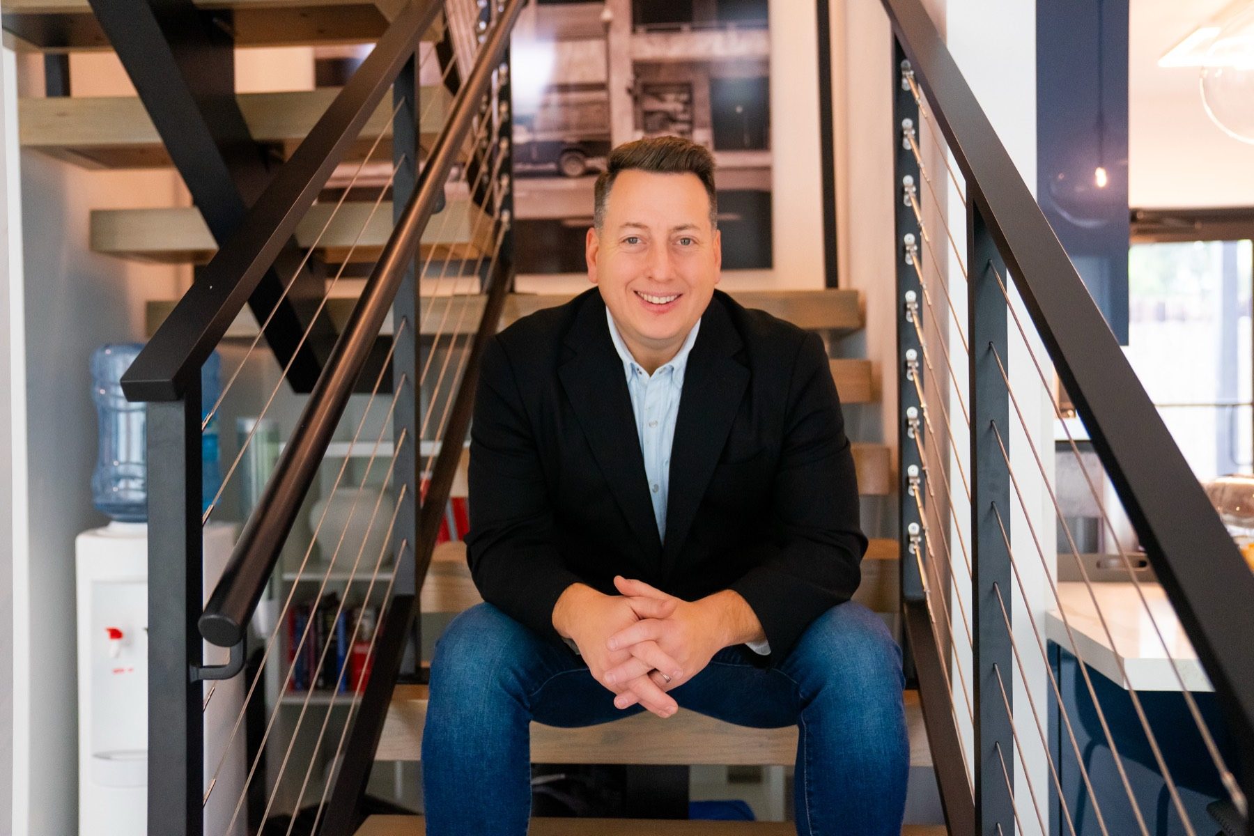 Tyler Kelley, founder of SLAM Agency, seated on the office stairs